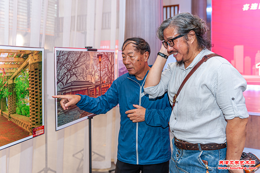 摄影社常务副社长张伟杰（右一）观展